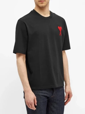 Svart t-shirt från Ami Paris med stor patch - Svart t-shirt från Ami Paris med röd hjärtdetalj och bokstaven A broderad på bröstet. Klassisk passform med rund hals och korta ärmar. Tillverkad i mjuk bomull som känns skön mot huden. Perfekt för en stilren och trendig look.