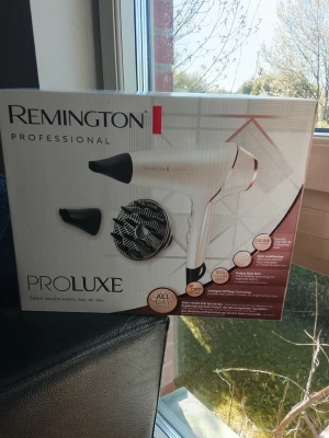 Remington PROLUXE hårfön - Remington PROLUXE hårfön i vit och roséguld med två munstycken och en diffuser. Ergonomisk design med kraftfull motor på 2400W. Perfekt för att styla håret snabbt och smidigt. Tillverkad i plast och metall, passar dig som vill ha salongskänsla hemma. Helt ny, oöppnad