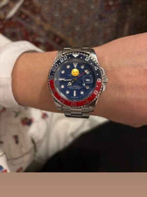 Blå-silver klocka med röd bezel - Fett r klocka. Mycket bra skick kommer även med flera länkar ifall den nu är för liten. Batteriet funkar perfa. Overall riktigt fin klocka 