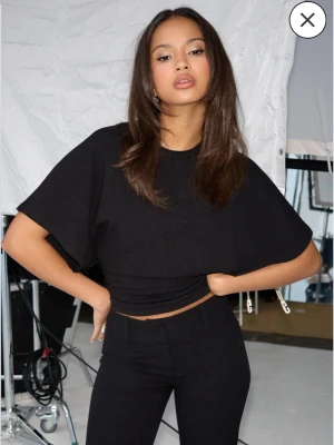 Nelly round neck wide sleeve tee  - Svart t shirt från Nelly storlek xxs i nyskick. Tajt i midjan med stängd rygg och vida armar 