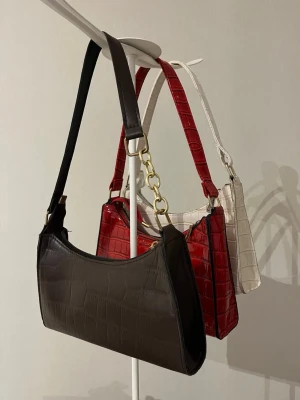 Tre handväskor - Säljer tre nästan oanvända väskor (en brun, en röd och en vit). 