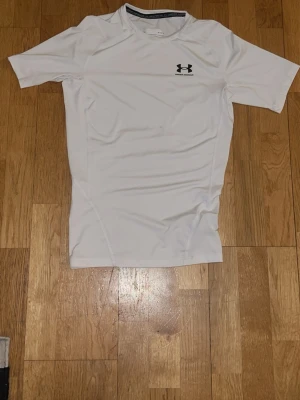 Vit träningströja från Under Armour - Vit under armour compression shirt i medium knappast använd.