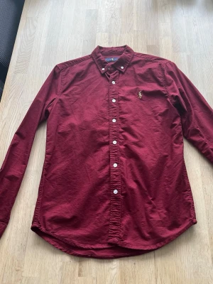Vinröd skjorta från Ralph Lauren - Klassisk vinröd skjorta från Ralph Lauren i storlek M men passar som S.