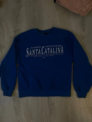 Blå Santa Catalina hoodie - Blå hoodie från Ginatricot i storlek Xs