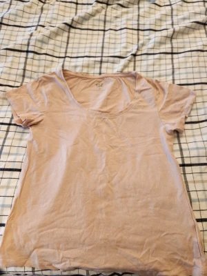 Beige t-shirt från 157 - En enkel beige t-shirt från 157 med rund halsringning och korta ärmar. Tillverkad i mjuk bomullsblandning (95% bomull, 5% elastan) som ger en skön och stretchig känsla. Perfekt basplagg till garderoben. Använder inte för att den är för stor man använd lite grann men inte mer än 3ggr. 
