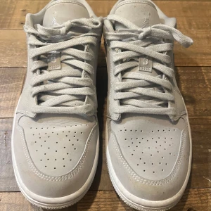 Grå Air Jordan 1 Low sneakers - Nike Air Jordan 1 Low sneakers i ljusgrått, strl 39. Säljer eftersom de inte kommer till användning. Använda lite grann, märks framförallt eftersom de är lite fläckiga och lite bruna på tårna (syns bäst på bild 3). Högerskon lite creasad. Jag kan skicka fler bilder vid önskan! Annars i fint skick! 