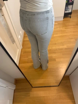 Ljusblå bootcut jeans - Hejhej!🌸 Säljer ett par ljusgrå bootcut jeans med klassisk femficksmodell och hög midja. Jeansen har en snygg tvätt och raka ben som slutar i en lätt utsvängning. Perfekta till sneakers eller boots för en avslappnad look. Dom är förstora och är använda max 2 gånger! Skriv ifall ni undrar något!💗