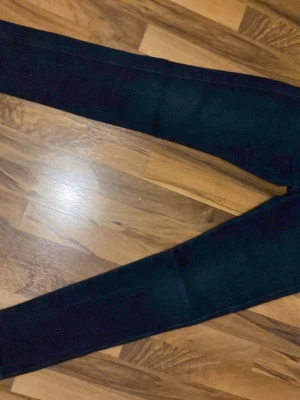 Mörkblå slim jeans - Säljer ett par mörkblå slim jeans med klassisk femficksdesign och smal passform. Jeansen har hög midja och är tillverkade i stretchigt material för extra komfort. Perfekta till en avslappnad look. 30W29L