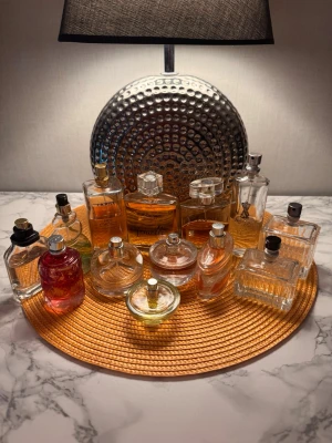 13 Mixade parfymer  - Samling med flera olika parfymflaskor. Mängd varierar se bilder. Inga korkar finns kvar och namn på vissa flaskor har försvunnit. Flaskor kan vara kantstötta. Bland märkena syns bland annat La Rive, Her Choice, Suddenly Femelle och Essence Jolie. Perfekt för dig som gillar att testa olika dofter. Alla 13 flaskor säljs ihop. 