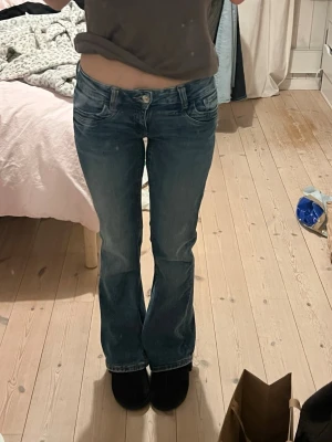 Lågmidjade bootcut jeans ginatricot  - Fina super lågmidjade jeans från Gina tricot  Dom är använt sparsamt. De är i storlek 158 men passar mig som har 34 - 36 på jeans. Innerbenslängden är 75 och midjemåttet är 33/34 dom är super stretchiga och har justerbar midja.