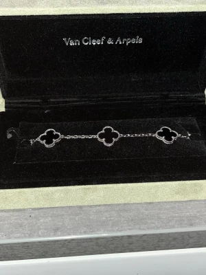 Van Cleef & Arpels Alhambra armband - Snyggt armband från Van Cleef & Arpels med ikoniska fyrklöverformade länkar. Armbandet är i silverfärg och har en tunn kedja som binder ihop de tre klöverformade detaljerna. Perfekt för dig som gillar exklusiva och tidlösa smycken.