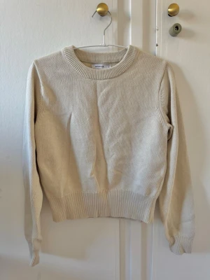 Beige stickad tröja från Reserved - En stilren beige stickad tröja från Weekday med rund halsringning och ribbade muddar vid ärmslut och nederkant. Tröjan har en rak passform och är tillverkad i mjukt material, perfekt för lager på lager under kyliga dagar 🩵