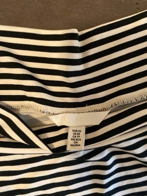 Randig offshoulder topp från H&M - Säljer en svartvit randig offshoulder topp från H&M i storlek XS. Toppen har smala horisontella ränder och korta ärmar. Perfekt för dig som gillar en enkel men trendig stil. Materialet är mjukt och stretchigt, troligtvis bomull med inslag av syntet.