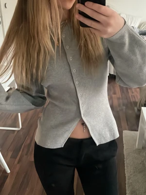 Grå tröja från Gina Tricot - Slutsåld tröja från Gina, nypris 459kr. Använd 3 gånger. Snygg grå kofta med unik sned knäppning framtill och rund hals. Långa ärmar och enkel, stilren design som passar till det mesta. 