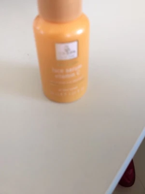 Mossa Vitamin C Face Serum - Fräsch ansiktsserum från Mossa med vitamin C i en orange plastflaska. Innehåller hyaluronsyra och vitamin E, passar alla hudtyper. Flaskan har en enkel och modern design med vit etikett och guldig text.