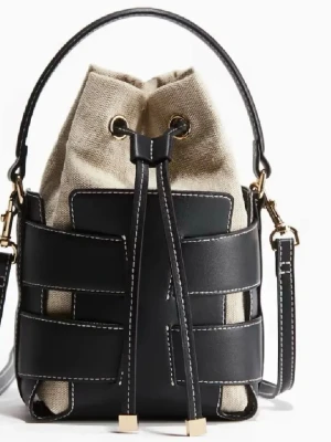 Svart Bucket bag - Trendig bucket bag i svart skinn och beige canvas med cool snörning framtill och vita kontrastsömmar. Väskan har en hög efterfrågan, ANVÄND 1 GÅNG.