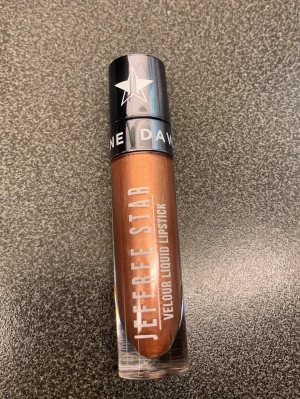 Jeffree Star flytande läppstift brons - Säljer ett Jeffree Star Velour Liquid Lipstick i färgen 'I Gotta Go'. Läppstiftet har en metallisk bronsig ton och kommer i en genomskinlig tub med svart lock och vit stjärndekor. Perfekt för dig som vill ha en statement-färg med metallic finish.