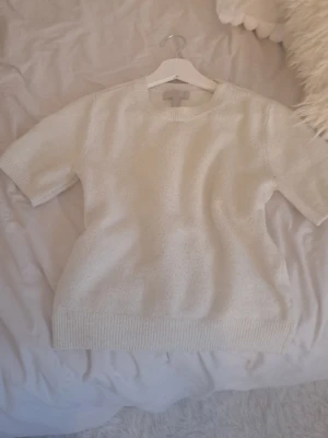 Vit stickad trekvartsärm tröja❤️ - En stilren vit stickad tröja med korta ärmar och rund hals. Tröjan har ribbstickade muddar vid ärmslut och nederkant. Perfekt för lager-på-lager och enkel att matcha med olika outfits.