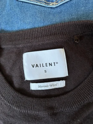 Mörkbrun merinoullströja Vailent - Snygg mörkbrun stickad tröja från Vailent i mjuk merinoull. Klassisk rund halsringning och långa ärmar med ribbade muddar. Perfekt för lager på lager och enkel att matcha med jeans..