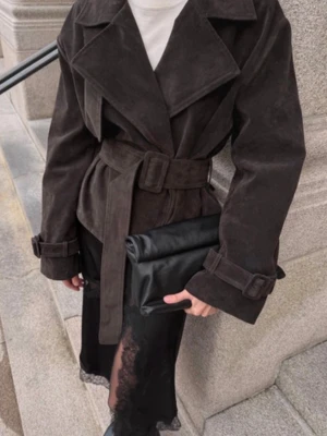 Mörkbrun kort rock med bälte mocka NA-KD - Stilren mörkbrun rock i mockaimitation med breda slag, bälte i midjan och justerbara spännen vid ärmsluten. Kortare modell som ger en trendig siluett och passar perfekt till lager-på-lager. Materialet har en mjuk, lyxig känsla.