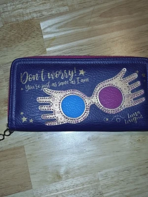 Luna Lovegood handväska  - Liten Luna Lovegood handväska utan handtag. Passar perfekt att ha sin mobil och andra värdesaker i.