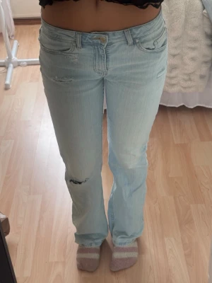 Ljusblå jeans med slitningar - Lågmidjade ljusblå jeans med slitningar 🥰 de är som nya. Passar perfekt på mig som brukar ha S/36 och år 165 lång 