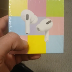 Vita trådlösa in-ear hörlurar - Säljer ett par vita trådlösa in-ear hörlurar med laddningsetui. Hörlurarna har en stilren och modern design med rundade former och svarta detaljer. Perfekta för musik, poddar eller samtal på språng.
