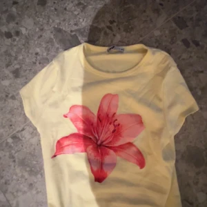 Gul t-shirt med röd blomma 🌸  - Superfin gul t-shirt från FB Sister med en stor röd blomma tryckt framtill💓😍. Storlek M men skulle säga att den passar S också🥰