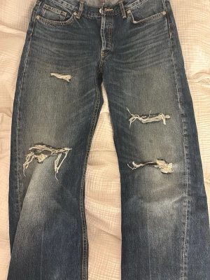 Blå wide/raka jeans - Säljer ett par blåa raka jeans med slitningar från Zara! säljer pga lite korta på mig! sprättade längst ner som visas på bilden!