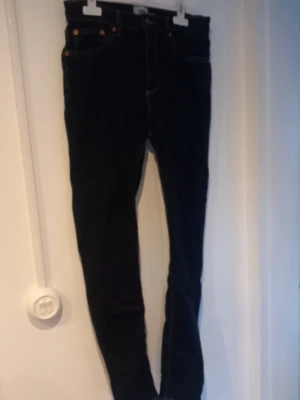 Mörkblåa skinny jeans med hög midja - Säljer ett par mörkblåa skinny jeans med hög midja och klassiska fem fickor. Jeansen har smal passform och kontrastsömmar. Perfekta för dig som gillar en enkel och stilren look.