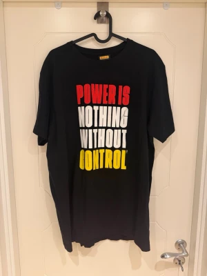 Svart Pirelli t-shirt med tryck - Säljer en svart t-shirt från Pirelli med stort färgglatt tryck på bröstet där det står 'POWER IS NOTHING WITHOUT CONTROL' i rött, vitt och gult. Klassisk rund hals och korta ärmar. Perfekt för dig som gillar motorsport och vill sticka ut.                                  Använd 1 gång.
