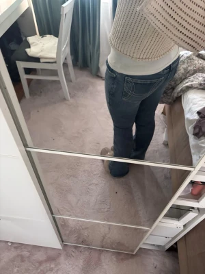 Blå bootcut jeans med broderad ficka - Säljer ett par blå bootcut jeans med snygg broderad detalj på bakfickan. Skulle säga att de inte är jätte low men ändå inte mid waist. Endast procat  2 gånger.