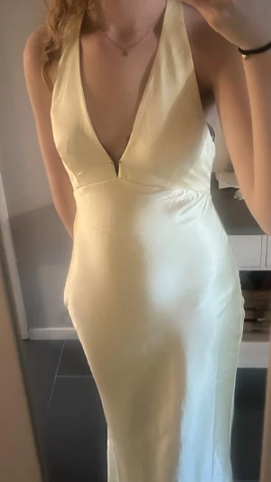 Gul satinklänning - Säljer nu min fina balklänning!💛Elegant långklänning i ljusgul satin med djup v-ringning. Materialet ger en lyxig och glansig känsla, perfekt för speciella tillfällen! Kom privat vid fler frågor🙏🏻