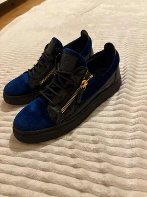 Blå sammetssneakers  Giuseppe Zanotti skor - Säljer mina blåa Giuseppe Zanotti skor. Har ställ på hyllan ett tag nu och tänkte att de va dags att sälja dem. Bra skicka och storlek 42, sitter bra på mig som har storlek 43. 