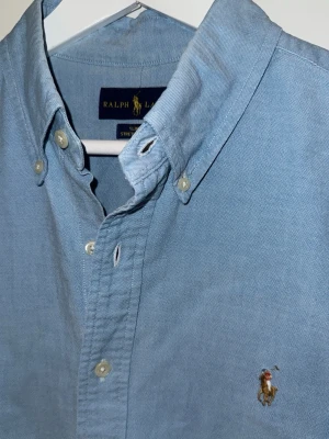 Ljusblå Ralph Lauren Skjorta - En snygg Ljusblå skjorta från Ralph Lauren. Den är i storlek L och är knappt använd, behövs bara en strykning så ser den ut som ny.