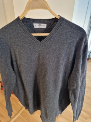 Alan Paine pullover - En tröja i fint begagnat skick som har mycket kvar att ge.  Färg: Mörkgrå Armhåla till armhåla: 117 cm Material: Bomull 92% Kaschmir 8%
