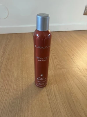 L'anza Healing Volume hårspray - Volymgivande hårspray från L'anza i serien Healing Volume. Flaskan är röd med silverfärgat lock och text i vitt. Produkten heter Final Effects och är perfekt för dig som vill ha extra volym och stadga till håret. Praktisk sprayflaska i metall.