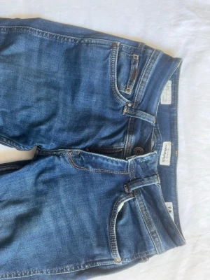 Blå jeans från Pepe Jeans London - Snygga blå jeans från Pepe Jeans London i modellen New Pimlico. Klassisk femficksdesign, låg midja och utsvängda ben.  Tillverkade i bomull med lite stretch för extra komfort. Perfekta till vardagslooken och lätta att matcha med olika stilar.