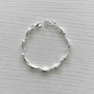 925 Sterling silverarmband - Snyggt armband i silverfärg med unika, böljande länkar som ger en modern och stilren känsla. Perfekt för dig som gillar minimalistiska smycken med det lilla extra. Lätt att matcha med andra accessoarer.