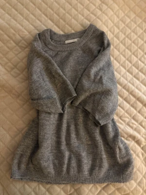 Grå stickad tröja från 157 - Mysig grå stickad tröja från 157 med rund halsringning och ribbade muddar vid ärmslut och nederkant. Materialet känns mjukt och bekvämt. Använd 1 gång💕