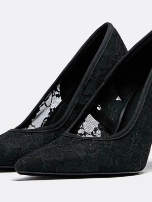 Svarta spetsiga pumps med spetsdetaljer - Säljer ett par eleganta svarta pumps med spetsiga tår och transparenta spetsdetaljer på sidorna. Skorna har hög klack och en stilren siluett som ger en lyxig känsla. Perfekta för dig som vill ha en unik och trendig look. Helt oanvända då jag köpte fel storlek