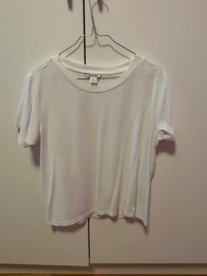 Vit soft t-shirt från Monki stl L - Passar från s-L beroende hur lösa man vill ha den. En enkel vit t-shirt från Monki med rund halsringning och korta ärmar. Tillverkad i mjuk bomull för en skön känsla och avslappnad passform. Perfekt att matcha med jeans eller kjol för en clean look.