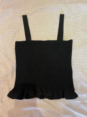 Smockat linne med volang - Svart smockat linne med volangkant! Från H&M
