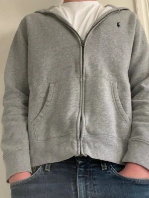 Grå hoodie från Polo Ralph Lauren - Riktigt snygg grå hoodie med dragkedja från Polo Ralph Lauren. 
