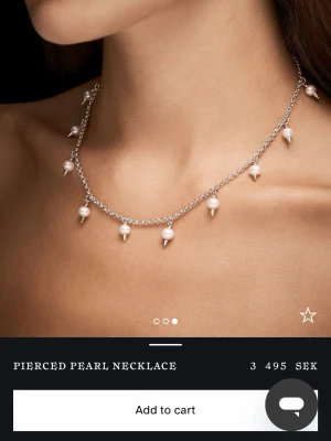 Helt ny Pierced Pearl Necklace i silver - Nytt aldrig använt Snyggt halsband i silver med vita pärlor och små metallspetsar som hänger längs kedjan. Kedjan är tunn och justerbar för perfekt passform. Perfekt för dig som vill ha en edgy twist på klassiska pärlor.