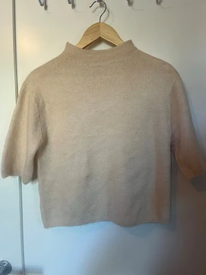 Beige stickad tröja Gina Tricot - Säljer en beige stickad tröja från Gina Tricot med halvpolo och korta ärmar. Barnstorlek men den passar perfekt på mig som bär S/M 