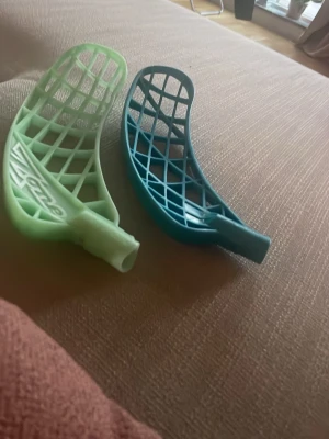 Nic andersson - Säljer två innebandyblad, ett ljusgrönt och ett mörkblått. Båda har ett rutnätmönster och är tillverkade i plast. Perfekta för dig som vill byta blad på din klubba eller testa olika former.