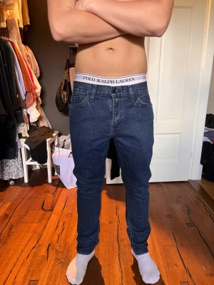 Mörkblå slim fit jeans från Levis line 8 - Säljer ett par mörkblå slim fit jeans från Levis line. Jeansen har klassisk design, normal midja och smal passform hela vägen ner. Tillverkade i stretchigt denim för extra komfort och snygg siluett. Storlek 32/32