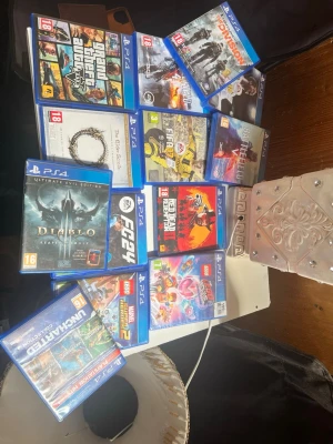 PS4 spelpaket med 11 titlar - Säljer ett paket med 11 PlayStation 4-spel, bland annat GTA V, Red Dead Redemption 2, Diablo III, FIFA 24, The Division, The Elder Scrolls Online och flera LEGO-spel. Alla spel har blå plastfodral och färgglada omslag. Perfekt för dig som vill utöka din samling med olika genrer.