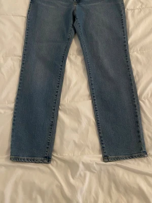 Blå raka jeans från Visual Clothing Project. Storlek W28, L30. ,  - Säljer ett par klassiska blå jeans från Visual Clothing Project med rak passform och normal midja. Jeansen har fem fickor, bälteshällor och dragkedjegylf. Perfekta till vardags och lätta att matcha med olika stilar. Materialet är denim i bomull.
